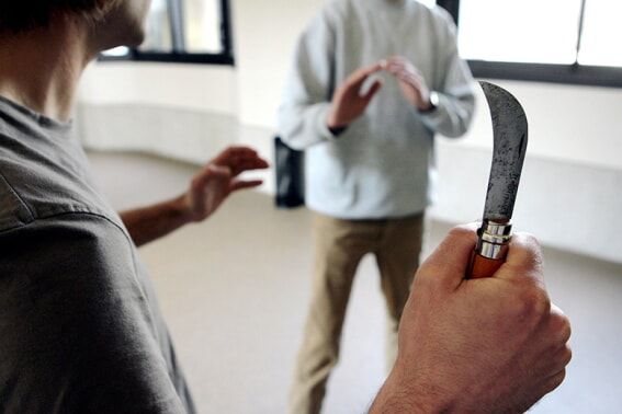 man with knife attempting to fight another man