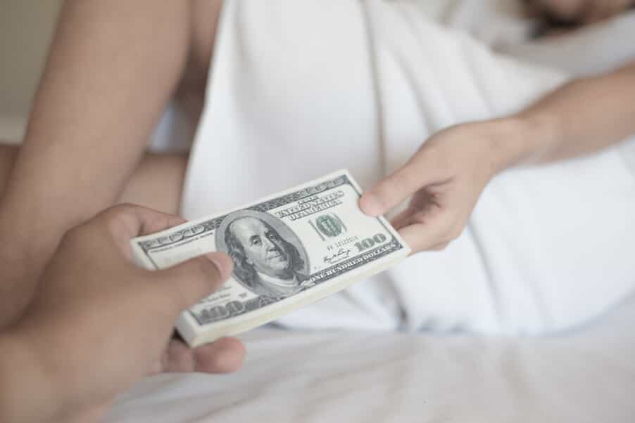 Two People in Bed Exchanging Money